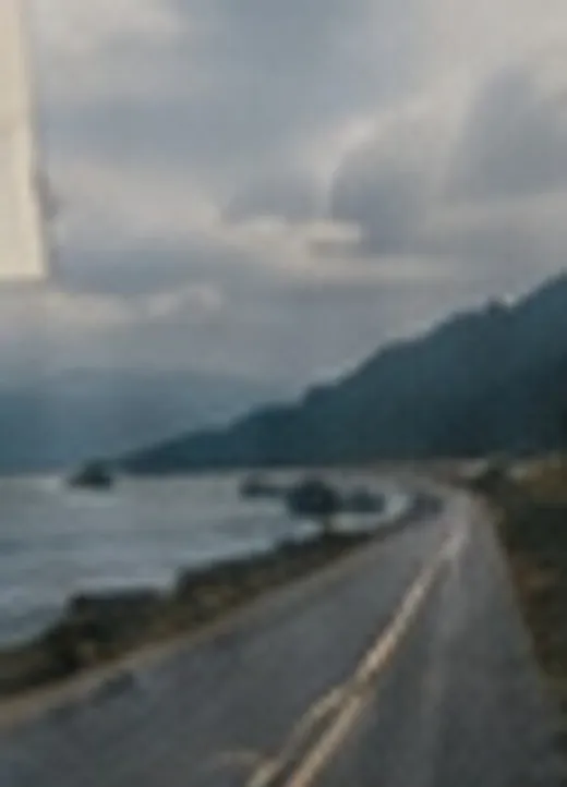 A two-lane highway curving along a coastline